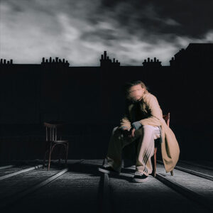 Photo de Kemmler assis sur une chaise, avec un effet de flou