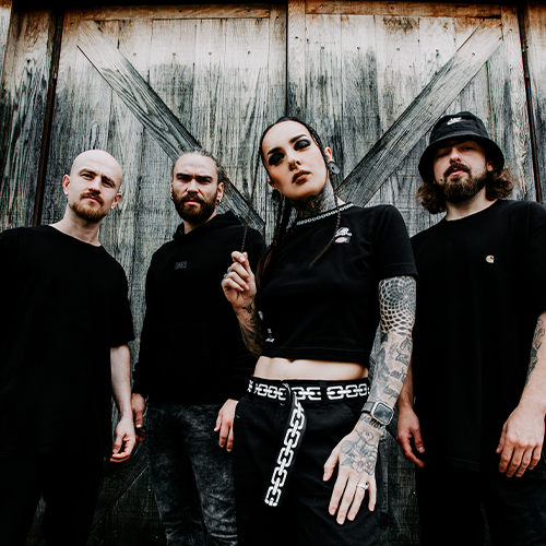 Photo des 5 membres du groupe Jinjer, devant une vieille porte en bois. Chaque membre fixe l'objectif et la photo est prise de bas.